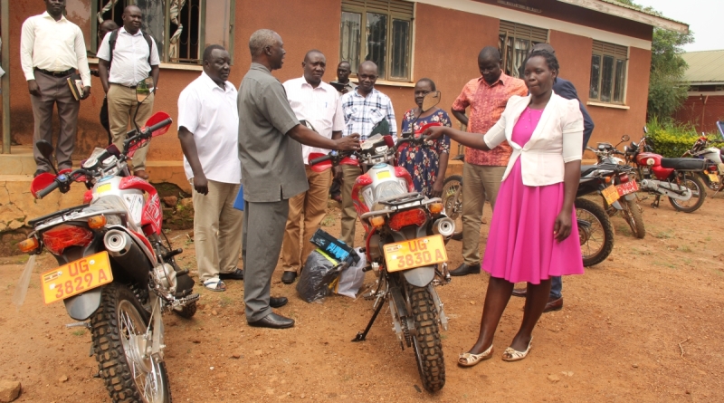 Chief Administrative Officer/Apac, Canon George Adoko hands over the key to Akech Caroline